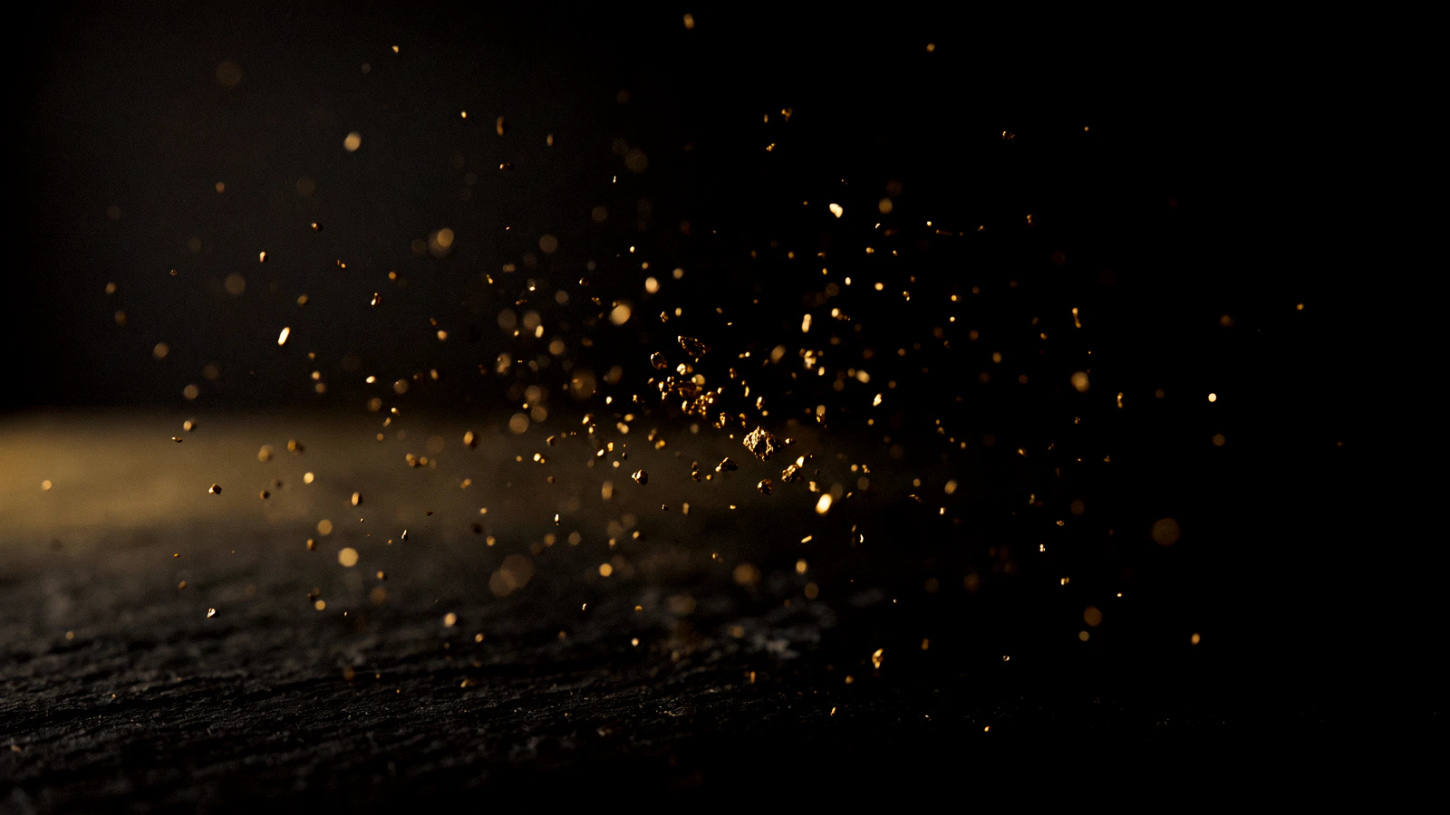 Hundreds of fine gold specks suspended in black air, a few of them sharp.